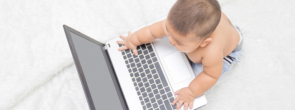 Photo: Baby with a laptop computer