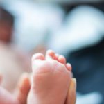 Photo: Father holding baby's feet