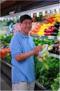 Man choosing vegetables at grocery store. 