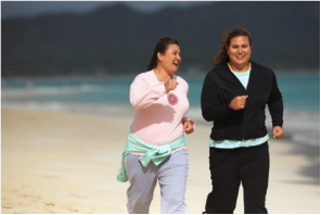 Two women running on the beach. 