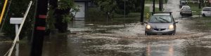 photo of car driving through flood waters even though they shouldn't