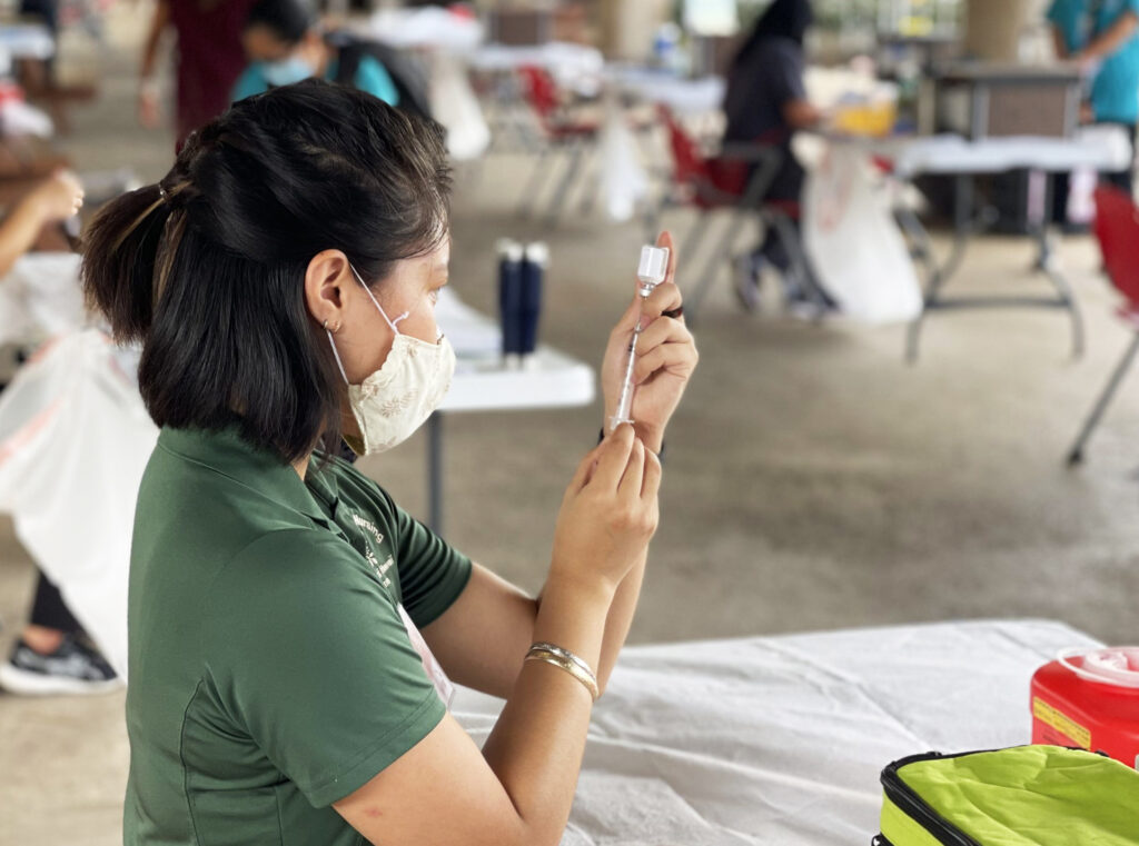 Person preparing a syringe with medication or vaccine
