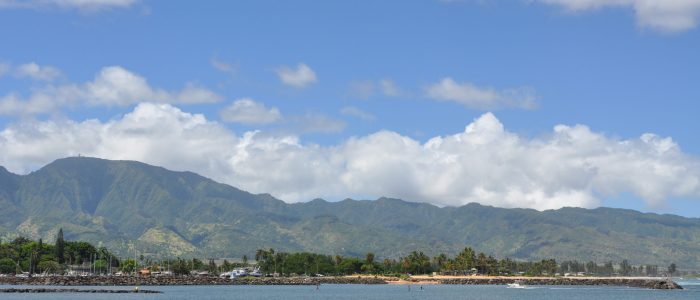 The Ko'olau Mountain Range stands tall, overlooking the ocean and boat harbor