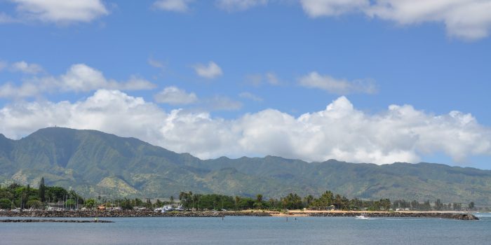 The Ko'olau Mountain Range stands tall, overlooking the ocean and boat harbor